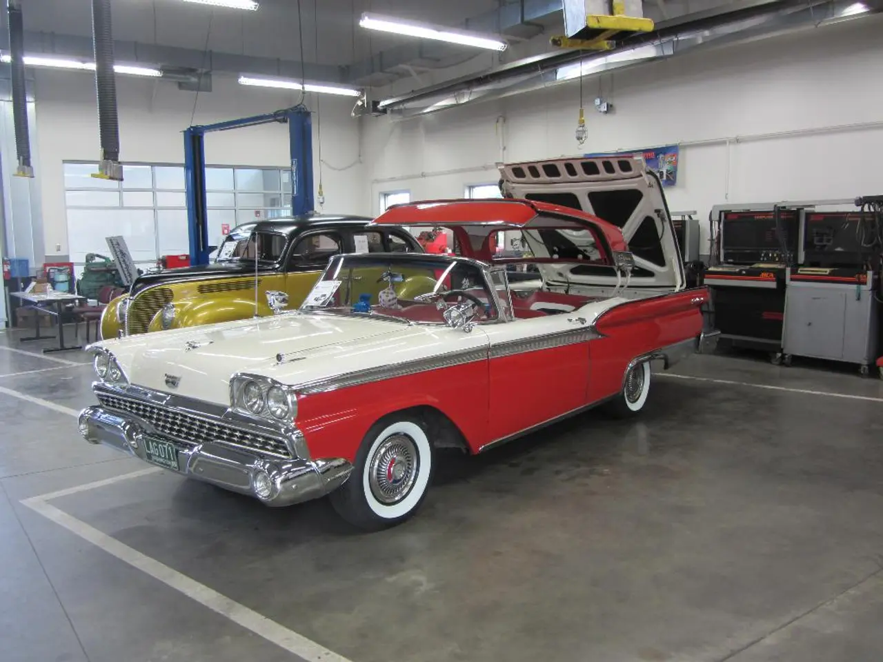 In this image I can see the vehicles. To the left there is table,chairs and some of the objects.