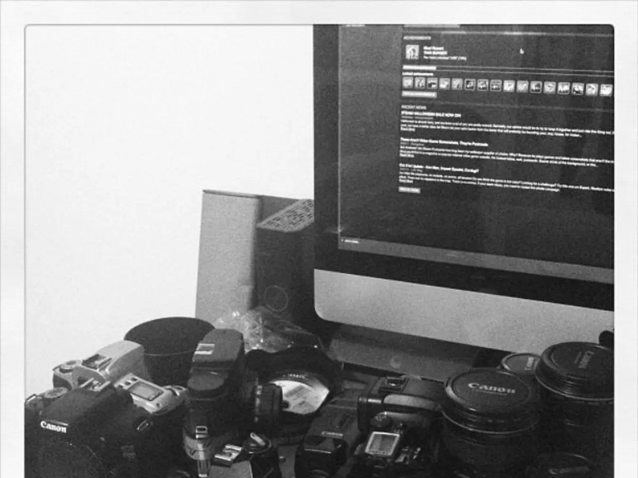 In this image there are few cameras, a computer, CPU and some other objects on the table.