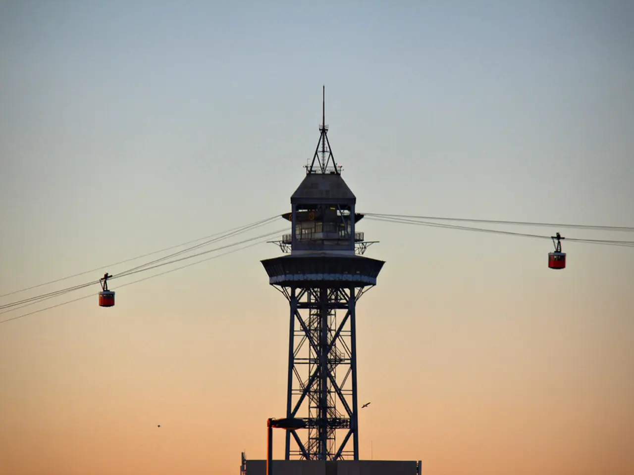 In this picture we can see couple of cable cars and cables, and also we can see a tower.
