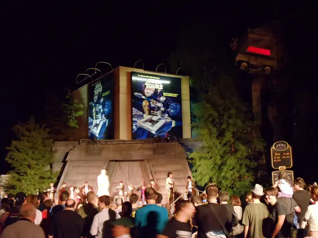 This picture is clicked outside the city. At the bottom of the picture, we see people standing. In...