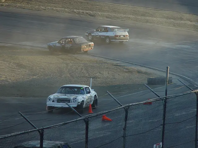 In this image, we can see a racing track and we can see some cars on the track, there is a tyre on...