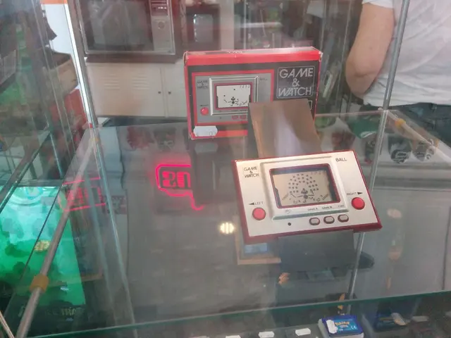 In this picture , I can see a game watch after that i can see a person standing next there are two...