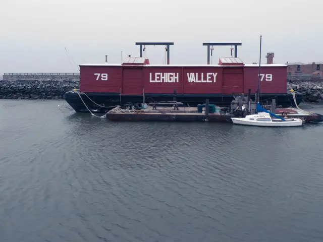 The picture is taken on the shore. In the foreground there is a water body. In the center of the...