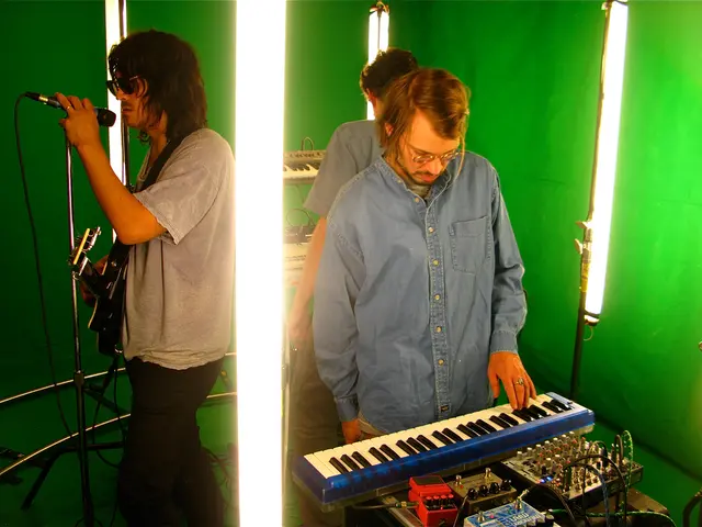 In this image i can see three men standing a man at right playing a piano, a man standing left...